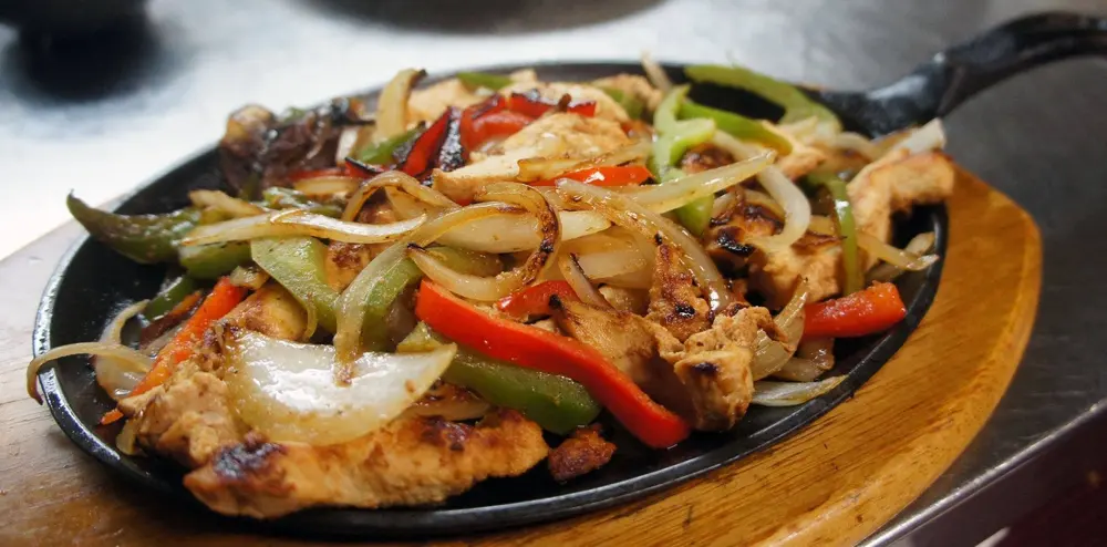 Sizzling fajitas on a cast-iron skillet